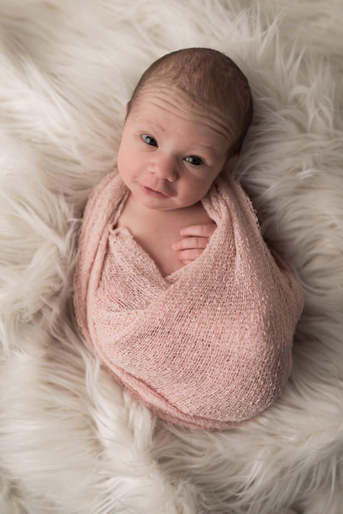 Neugeborenes guckt interessiert in die Kamera