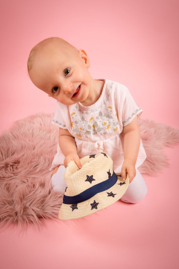 Mädchen beim Kinderfotoshooting im Studio mit rosa Hintergrund