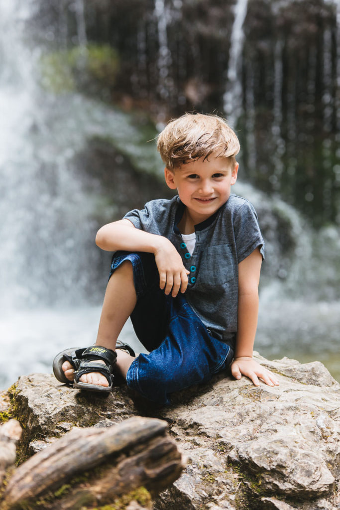 Cooler Junge vor dem Wasserfall