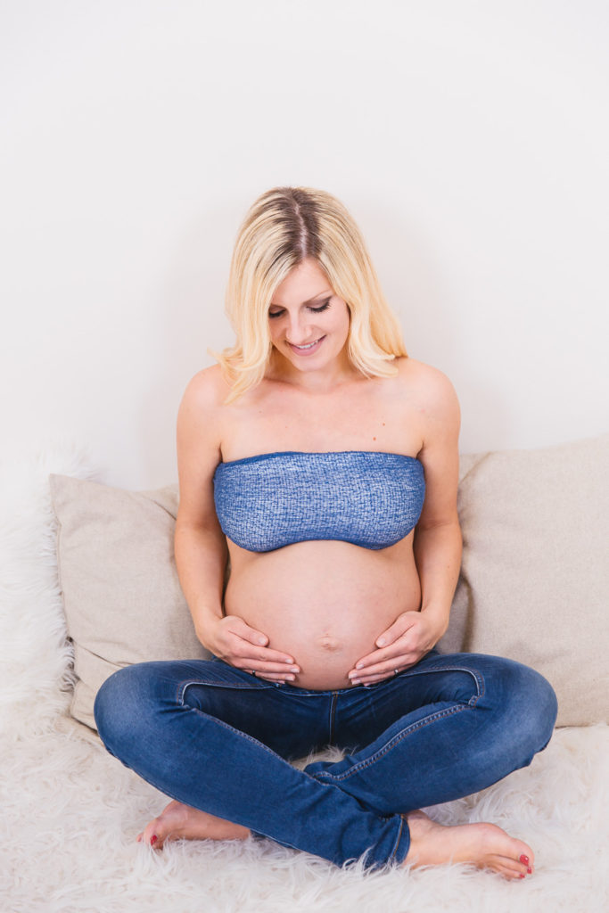 Babybauchfoto einer werdenden Mutter mit Jeansoutfit